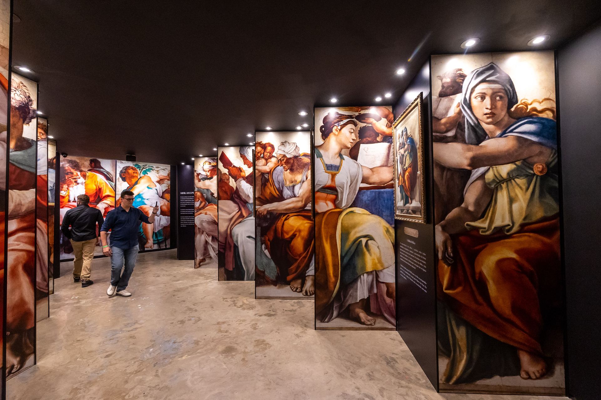 Convidados caminhando entre os painéis da Sistine Chapel no MIS