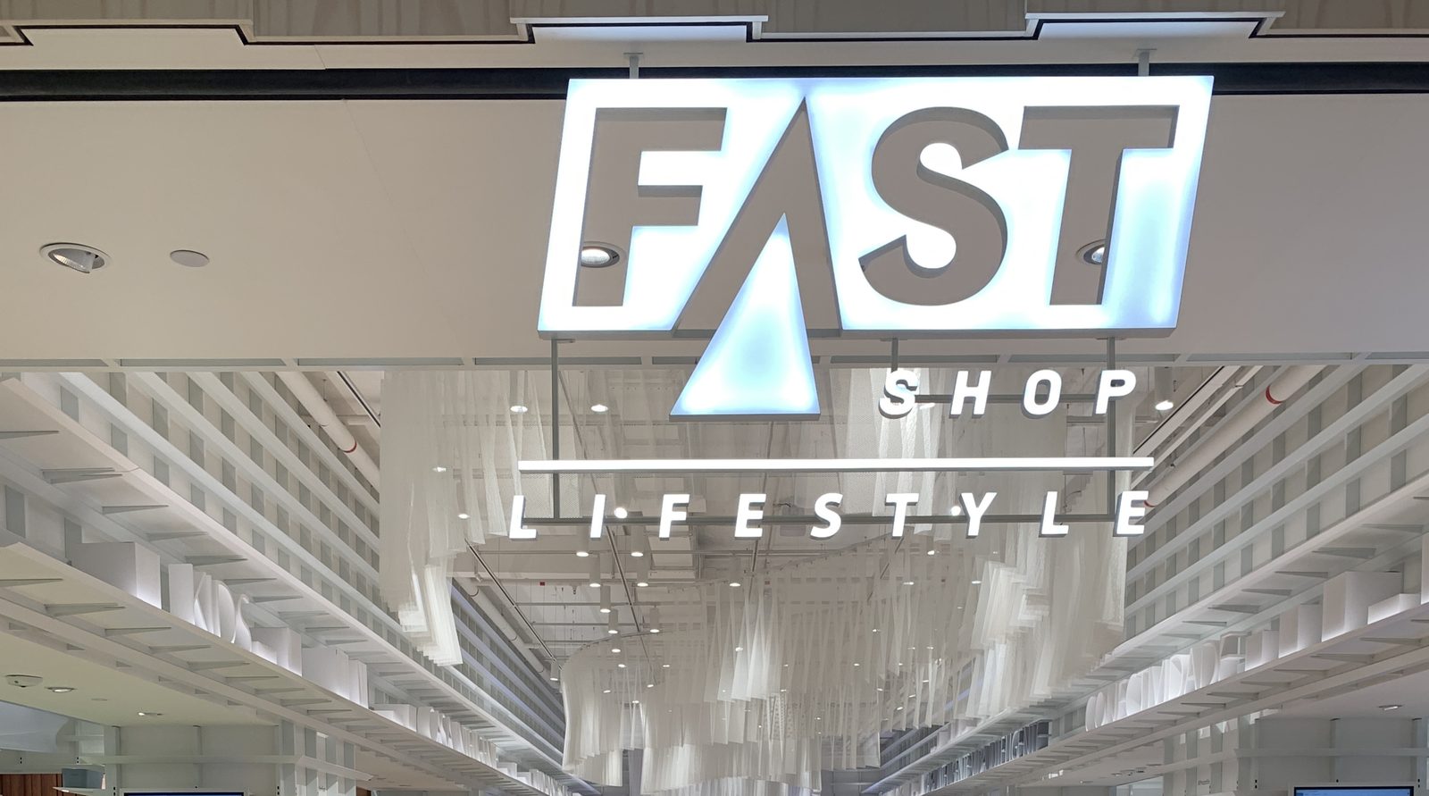 Entrada da Fast Shop Lifestyle com instalação de cortinas brancas
