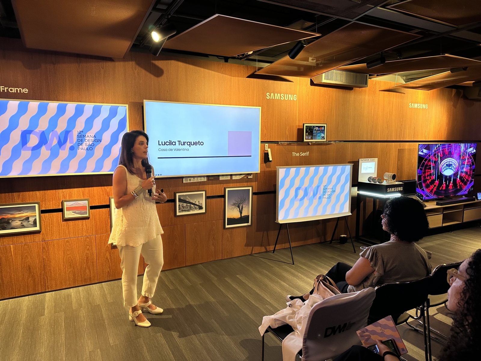 Lucila Turqueto conduzindo talk com The Frame Samsung e logo DW! Semana de Design ao fundo