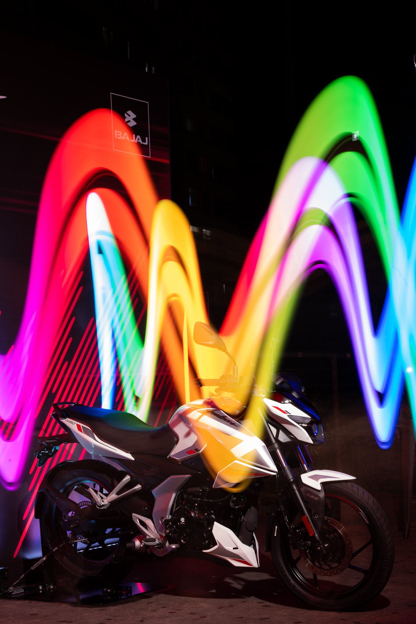 Pulsar N150 branca com efeito de light painting colorido